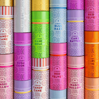 Colorful rows of Jenna Rae Cakes Liquid Cake Batter bottles in a package of 6, featuring pastel shades and flavors like sugar cookie, lemon candy, blue razz, red velvet, and cake batter with patterned labels.