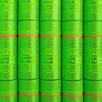 Packages of Jenna Rae Cakes Liquid Candy Melon, each containing six bright green cylinders with bold text and circular patterns, are stacked together to create a vibrant, repeating display.