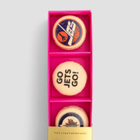 The Macaron Message Gift Box by Jenna Rae Cakes features three cookies in a pink box: one with a blue and orange logo, one with GO JETS GO!, and one with a blue, red, and white jet-themed logo.