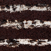 Close-up of the Chocolate Oreo Cake by Jenna Rae Cakes, showing layers of dark chocolate sponge and white cream filling with Oreo cookie pieces blended into the cream.