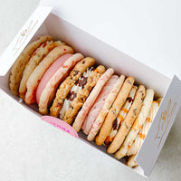 The Cookie Sandwich Gift Box by Jenna Rae Cakes features six large, assorted cookies in different flavors and colors, neatly arranged in a white box on a light background.