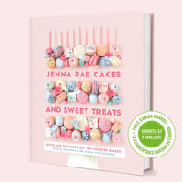 The Jenna Rae Cakes and Sweet Treats Cookbook by Jenna Rae Cakes has a pink cover with colorful desserts like macarons and cupcakes, plus a green sticker showing it’s a Taste Canada Awards shortlist finalist.