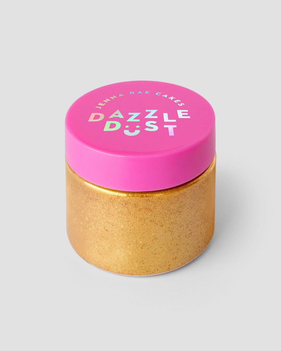 A gold jar with a bright pink lid labeled FND TESTING - 24k Magic Edible Glitter (Copy) by Jenna Rae Cakes contains edible glitter, shown against a plain gray background.