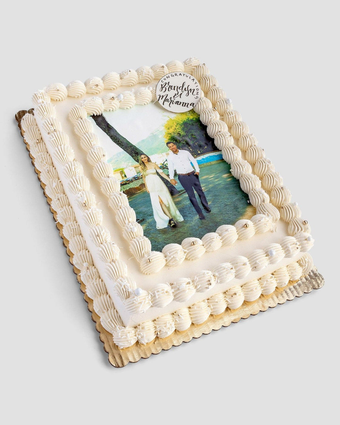 The Classic Sheet Cake by Jenna Rae Cakes features white frosting, piped borders, and an edible photo of a couple holding hands outdoors, finished with a small Congratulations plaque in the top corner.