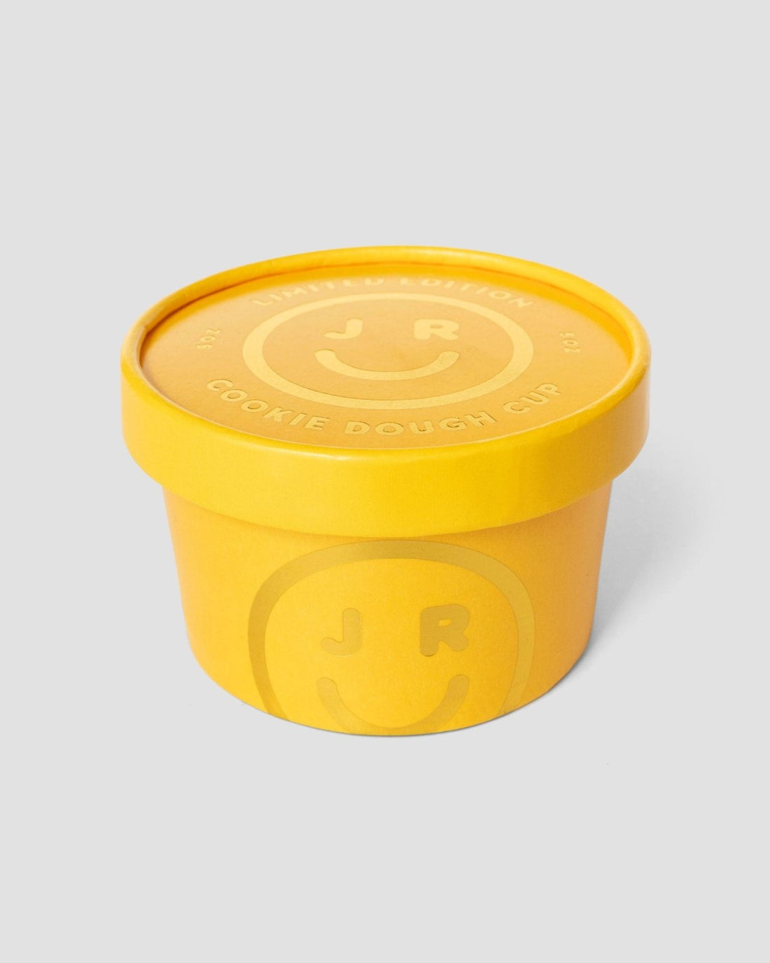 A yellow Cookie Dough Cup with a matching lid features the Jenna Rae Cakes name and a smiley face logo, displayed against a plain light gray background.