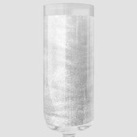 A clear champagne glass filled with sparkling Jenna Rae Cakes Diamond Edible Glitter shines against a light gray backdrop. Shown: 20g container, package of 3.