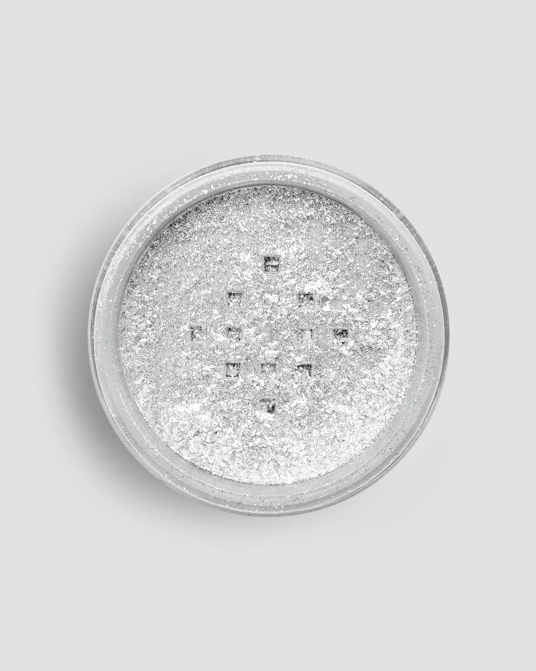 A round container of Jenna Rae Cakes Dazzle Dust Best Seller Trio is filled with fine, shimmery silver glitter powder, shown from above against a light gray background.