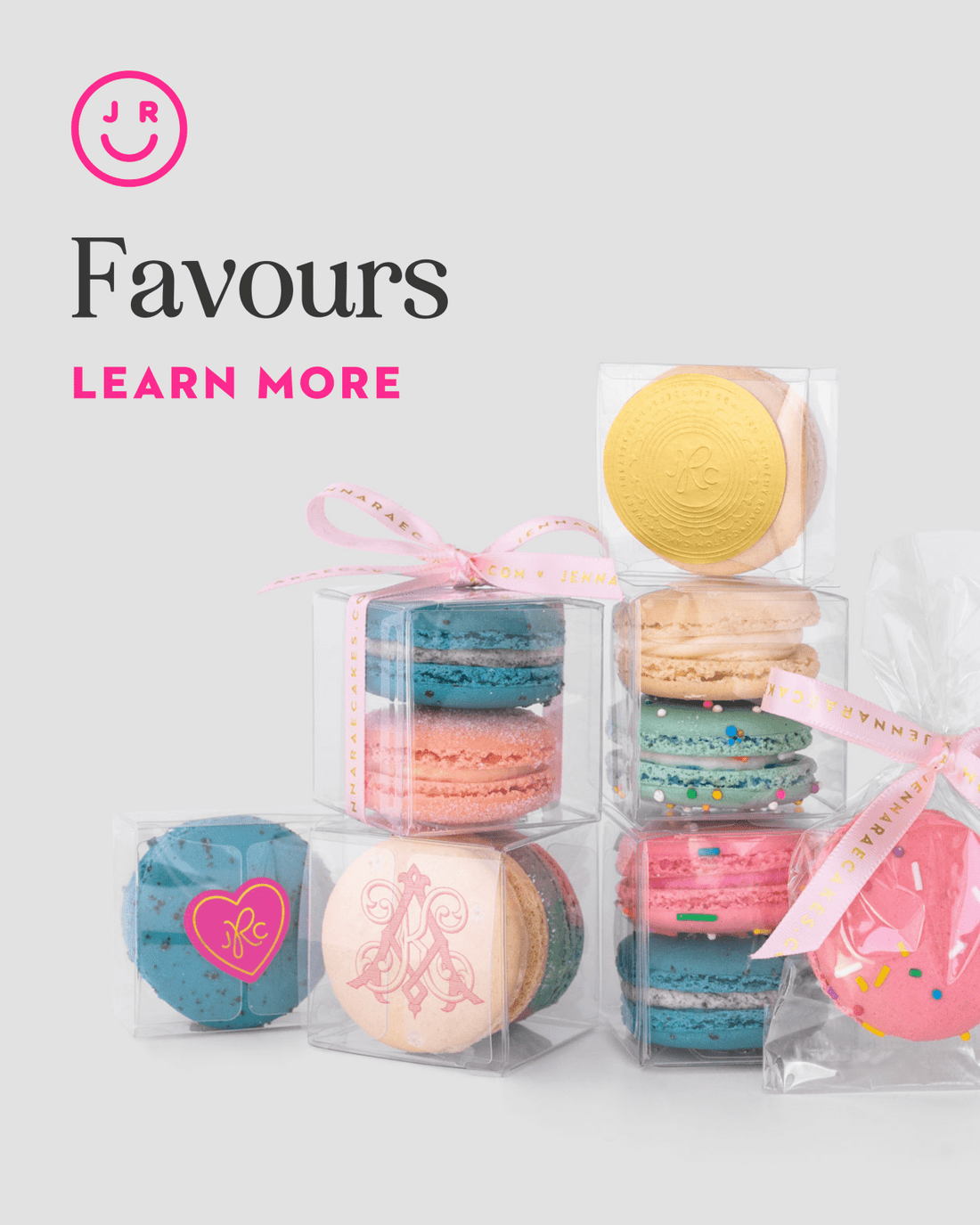 Colorful Jenna Rae Cakes Favours macaron gift boxes, some tied with pink ribbons, are stacked on a light background. A pink smiley logo appears above the text “Favours Learn More.”.