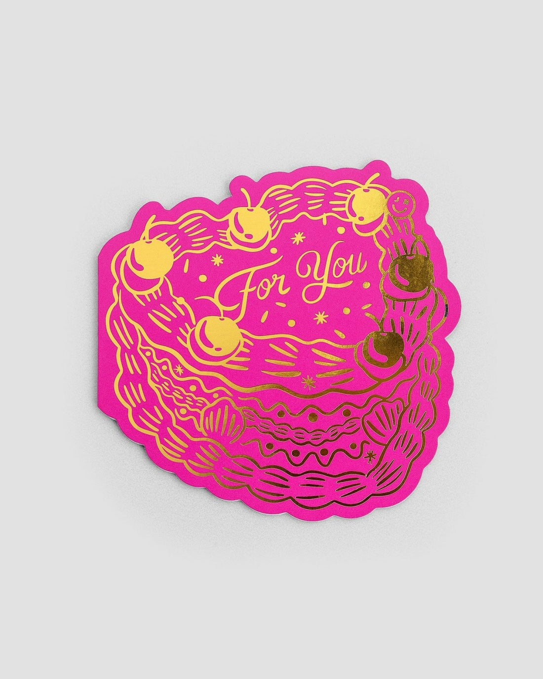 The For You Greeting Card by Jenna Rae Cakes features a bright pink cake shape with yellow and gold icing, cherries, and “For You” in the center, displayed on a plain light gray background.
