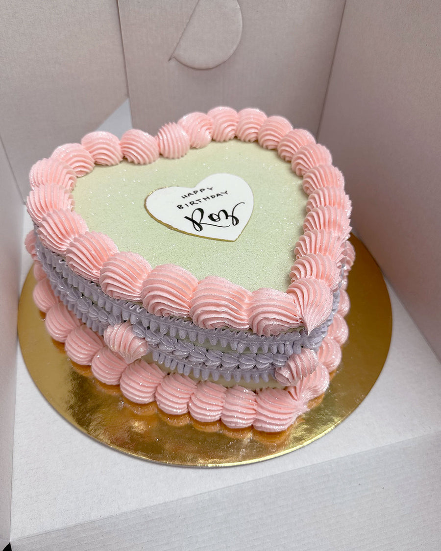 Design This Cake - Cake Size: Short | Cake Colour: Soft Sage Green | Piping Style: Fancy | 2 Piping Colours | Piping Colour 1: Soft Pink | Piping Colour 2:  Lavender | Make It Sparkle! | Add Heart Greeting Plaque