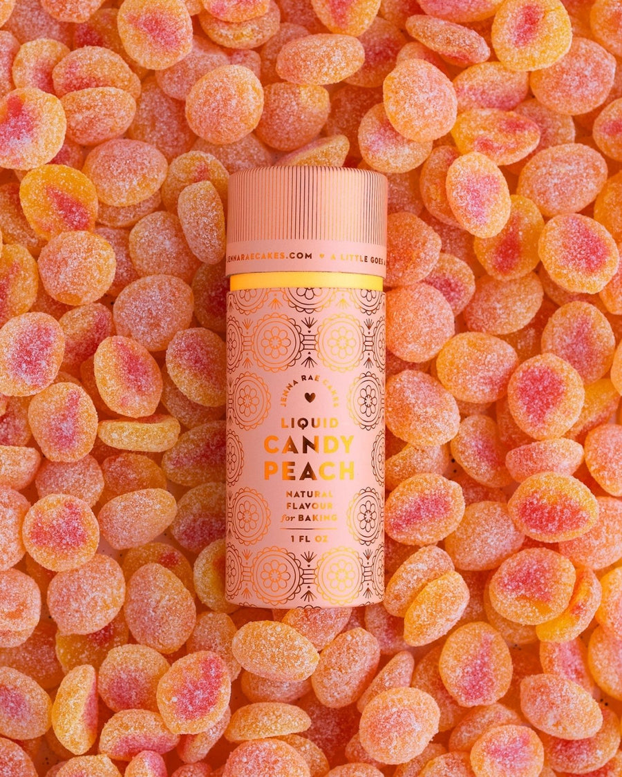 A package of 6 Jenna Rae Cakes Liquid Candy Peach containers rests on sugar-coated peach gummies. The pink and orange labels display decorative patterns and natural flavors information.