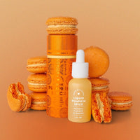 Orange pumpkin macarons surround a bright orange canister and a small dropper bottle, both labeled Liquid Pumpkin Spice by Jenna Rae Cakes, set against an orange gradient background.