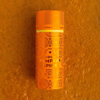 A small orange bottle of Jenna Rae Cakes Liquid Pumpkin Spice rests on an orange textured surface, adorned with decorative patterns and labeled as a natural baking flavor.