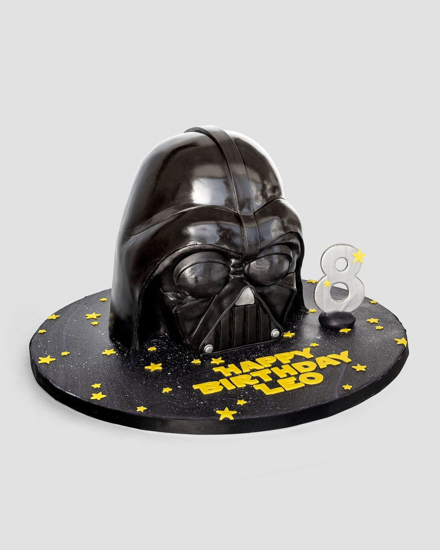 One-of-a-Kind Cakes by Jenna Rae Cakes: A Darth Vader helmet birthday cake with yellow stars, “Happy Birthday Leo” message, and a silver number 8 candle on a round black base.