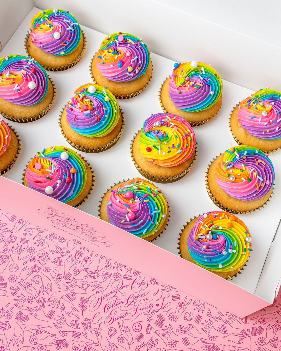 Jenna Rae Cakes’ Rainbow Cupcakes come in a light pink, whimsically patterned box. Each dozen features cupcakes with rainbow swirl frosting and assorted sprinkles.
