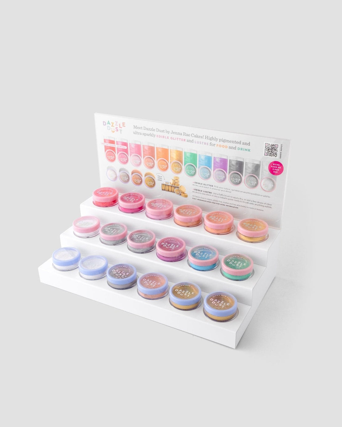 A White Acrylic Dazzle Dust Stand by Jenna Rae Cakes holds colorful pigment powders in small round containers, with a color chart and product info card displayed at the back. Package of 1.