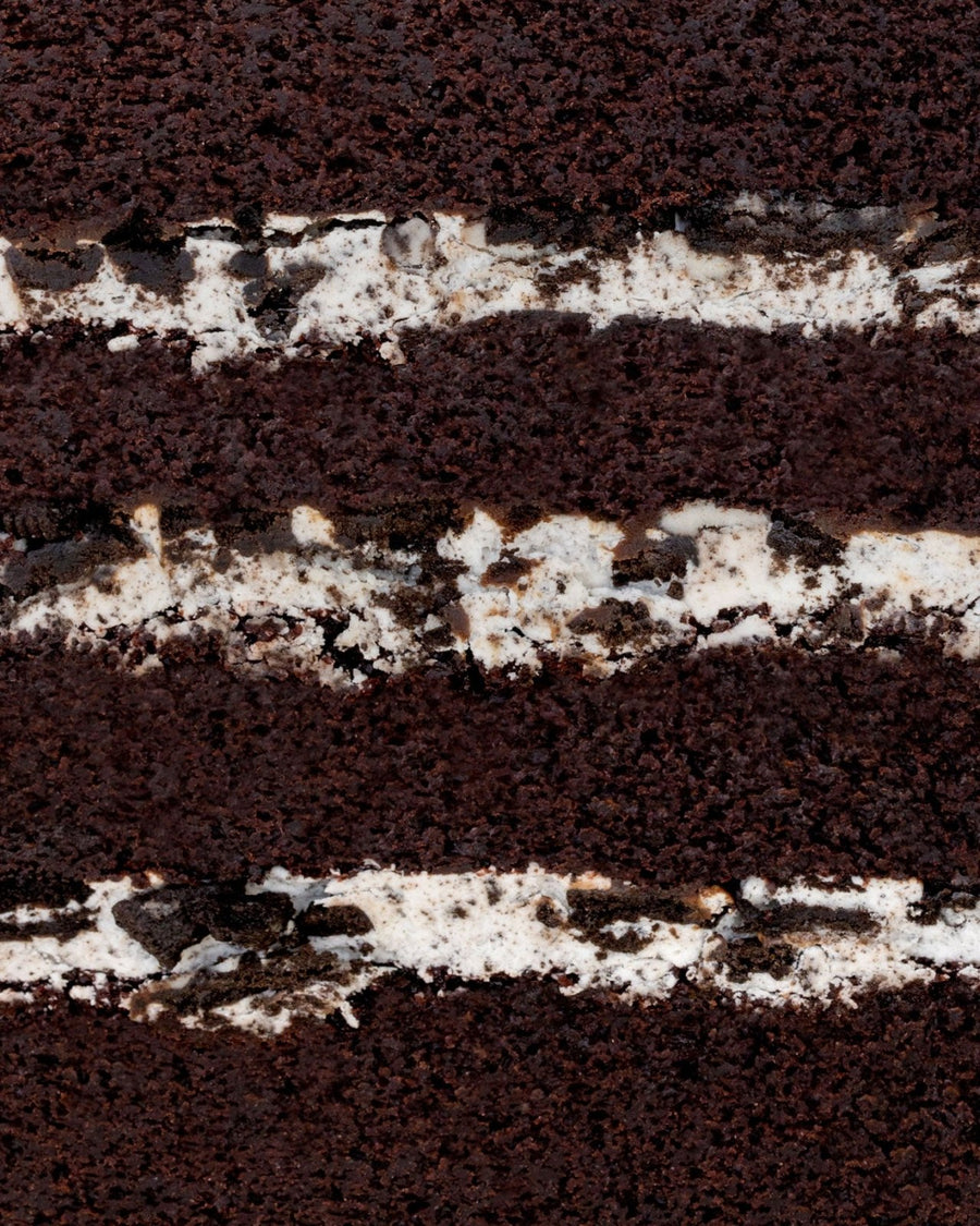 Close-up of the Chocolate Oreo Cake by Jenna Rae Cakes, showing layers of dark chocolate sponge and white cream filling with Oreo cookie pieces blended into the cream.