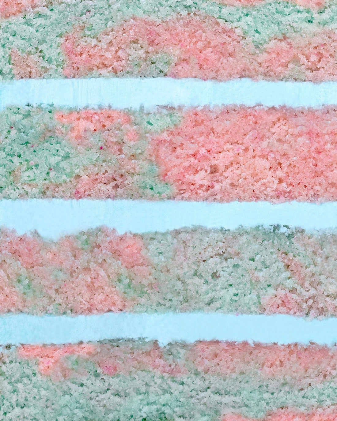 A close-up of Jenna Rae Cakes’ Cotton Candy Cake shows pastel pink, green, and blue layers with a soft, fluffy texture resembling abstract stripes.