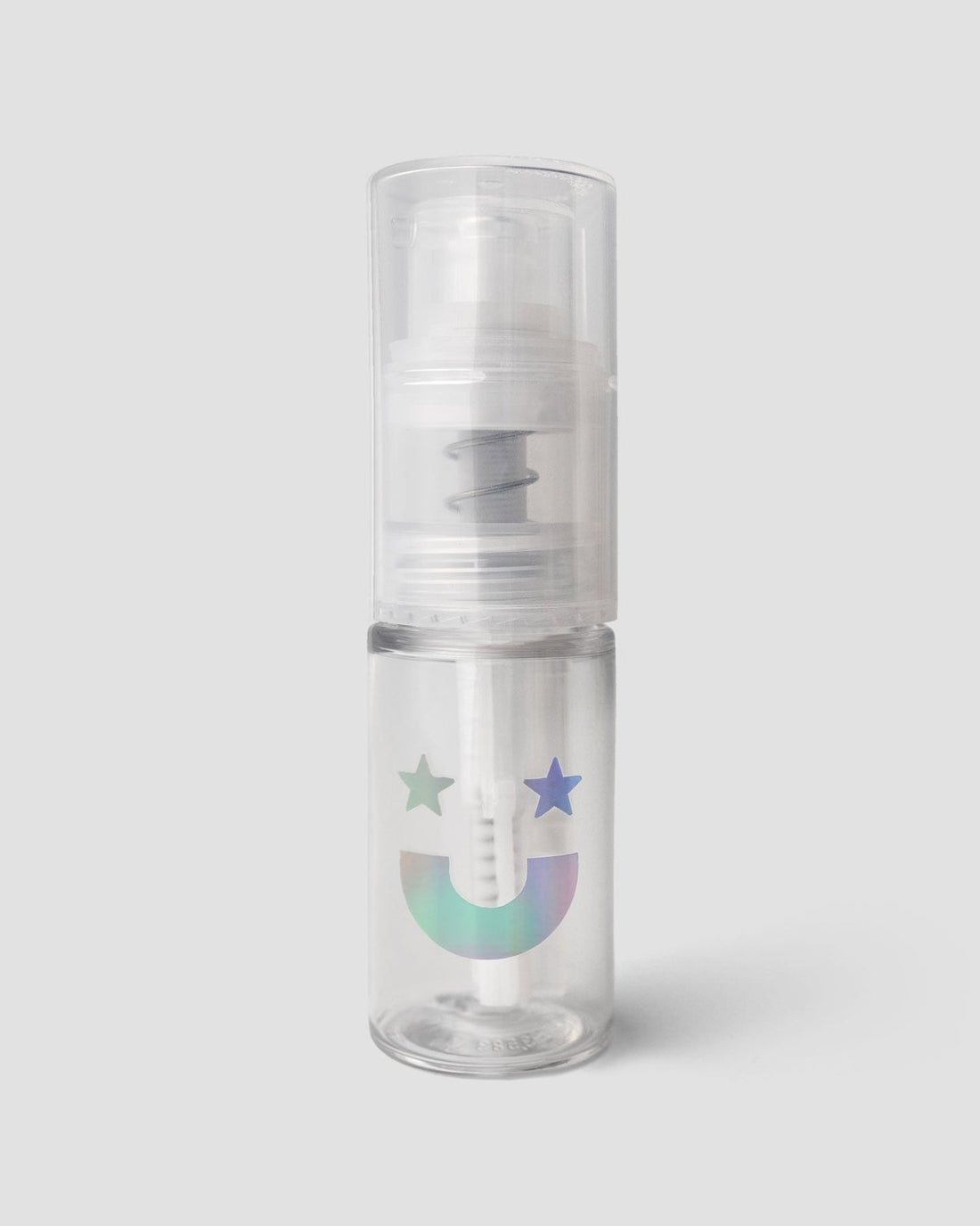 The Jenna Rae Cakes Dazzle Dust Pump and Funnel is a small, clear plastic spray bottle with a pump top, featuring a holographic smiley face and two stars, pictured against a plain light gray background.
