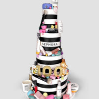 Jenna Rae Cakes’ One-of-a-Kind Cakes features a tiered black-and-white striped cake, adorned with Sephora-themed fondant, topped with makeup and skincare items, and finished with a gold 100 to celebrate Sephora’s 100th anniversary.