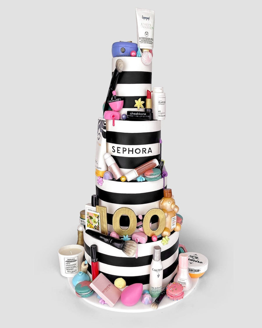 Jenna Rae Cakes’ One-of-a-Kind Cakes features a tiered black-and-white striped cake, adorned with Sephora-themed fondant, topped with makeup and skincare items, and finished with a gold 100 to celebrate Sephora’s 100th anniversary.