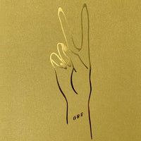 The Peace Greeting Card by Jenna Rae Cakes features a minimalist gold illustration of a hand making a peace sign, with the number 580 near the wrist.