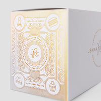 The Sweet Treat Gift Box by Jenna Rae Cakes is a white bakery box with gold embossed cake, cupcake, and macaron icons, featuring the brand’s logo and elegant decorative patterns.