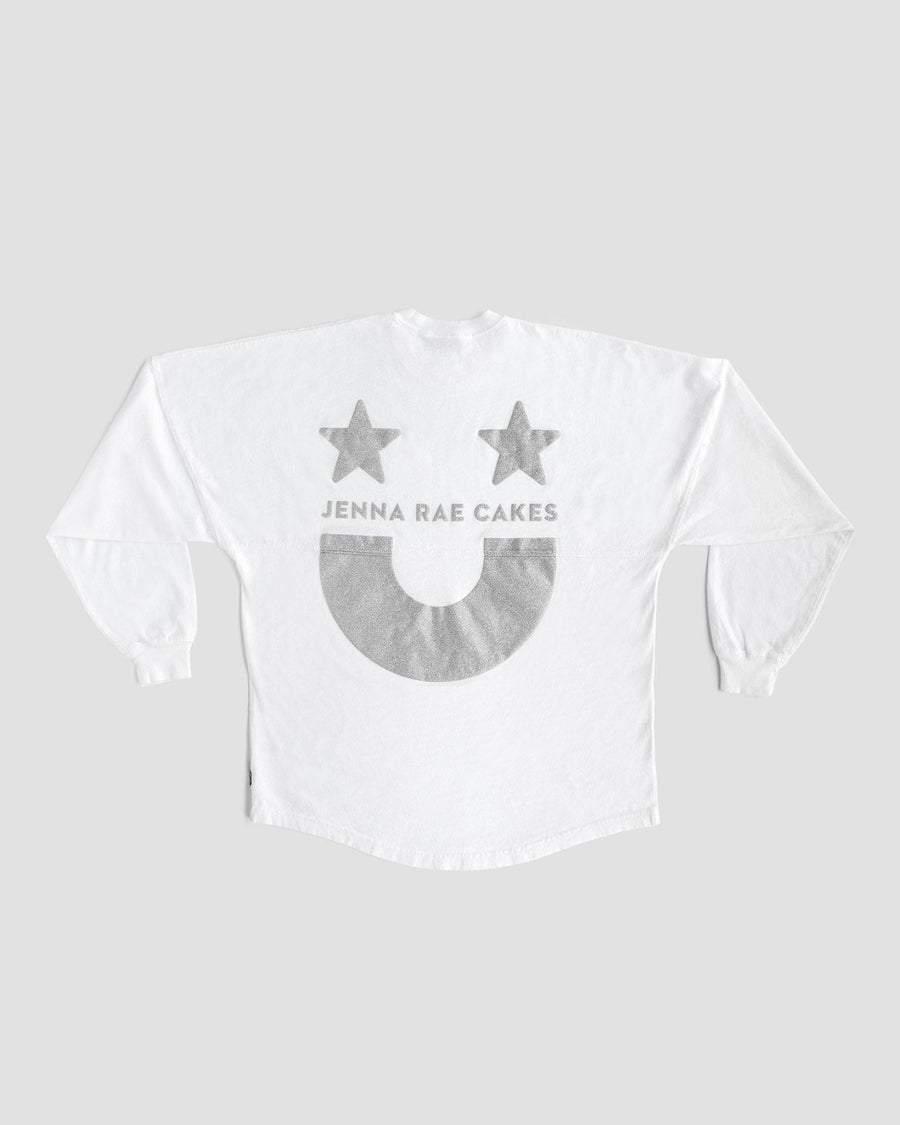 The White and Silver Spirit Jersey by Jenna Rae Cakes features two gray stars, “JENNA RAE CAKES” text, and a large gray smiley face on the back, shown on a plain gray background.